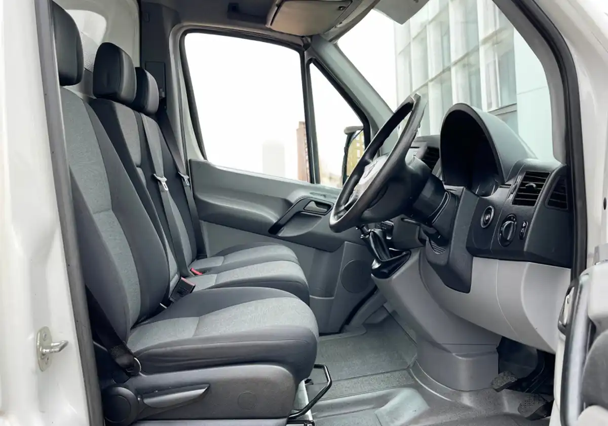 the interior of a Volkswagen Crafter Dropside with seats and a steering wheel.