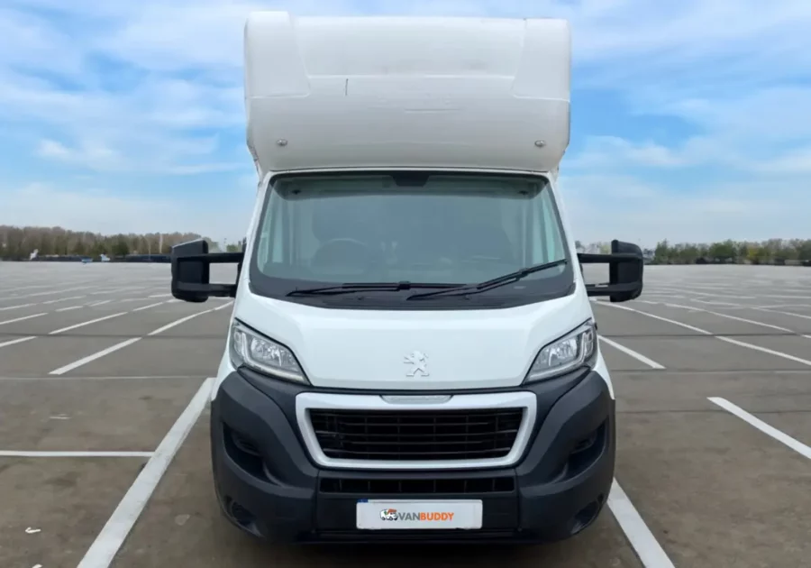 a white Peugeot Boxer Low Loader parked in a parking lot.