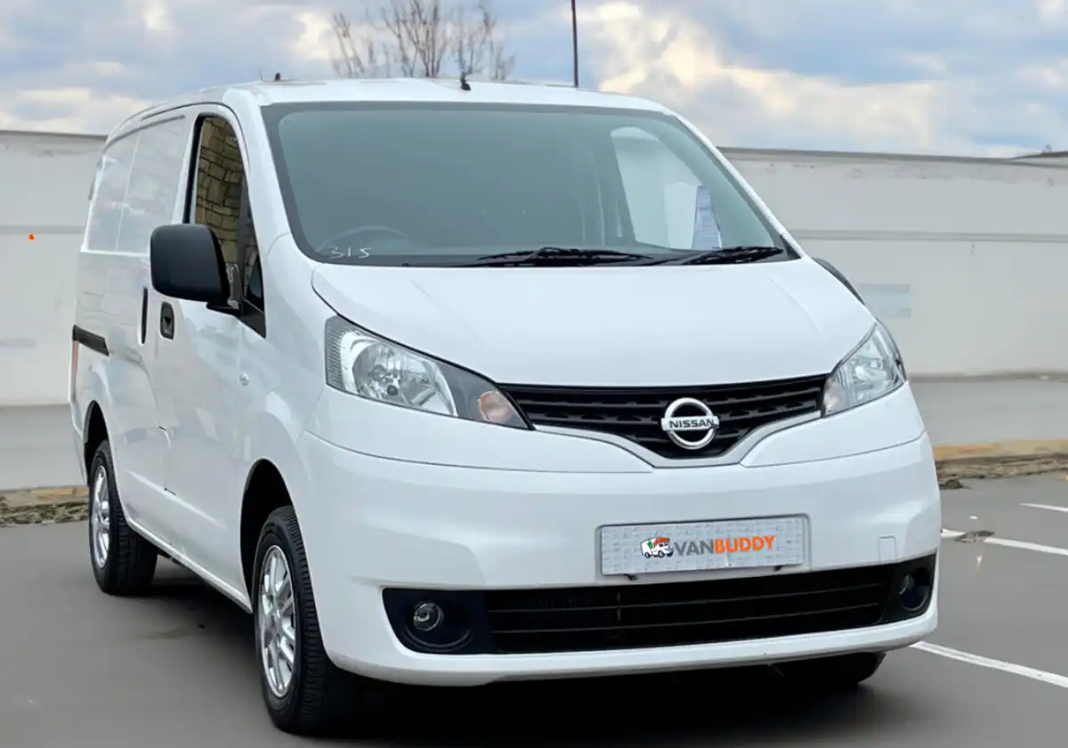 a white Nissan NV200 parked in a parking lot.