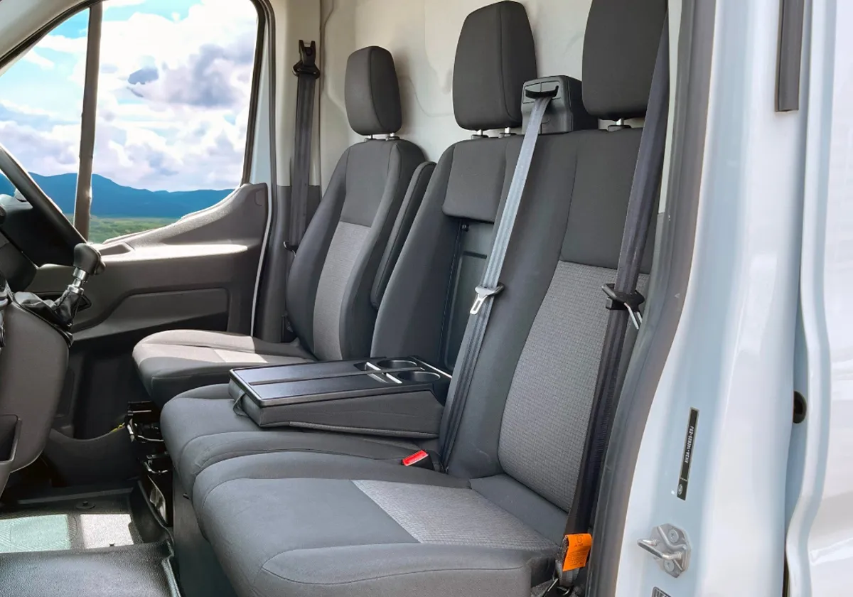 the interior of a Ford Transit Leader with black seats.