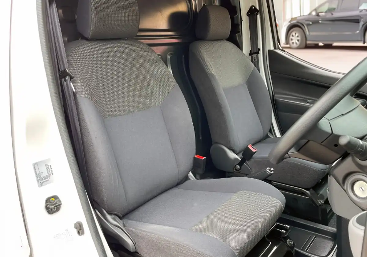 the interior of a Nissan NV200 with gray seats.