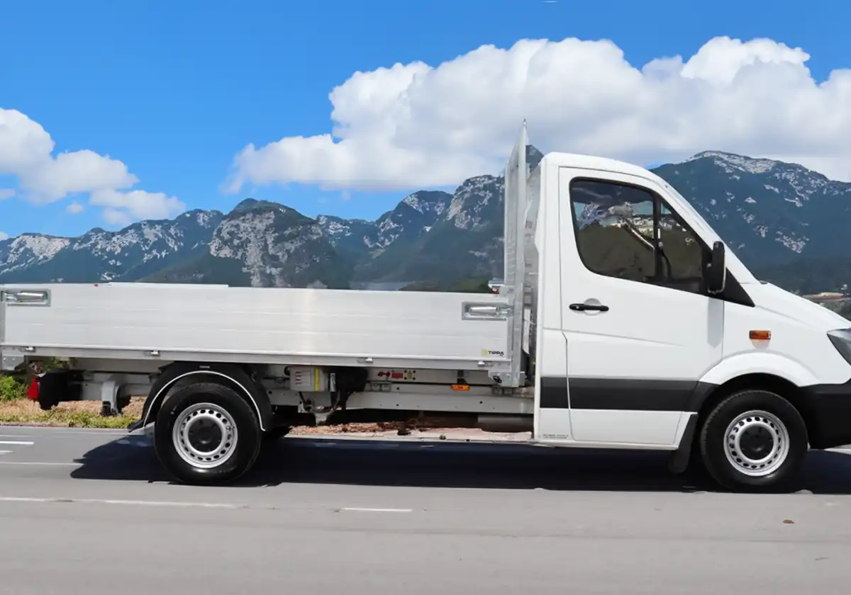 a white Mercedes Sprinter Tipper is parked on the side of the road.
