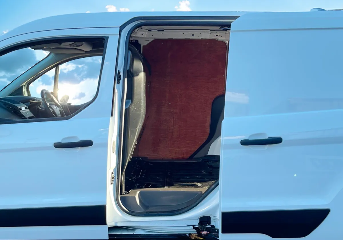 the door of a white Ford Transit Connect with the door open.