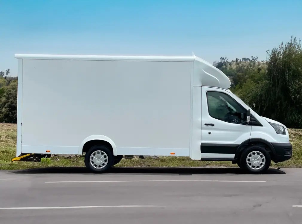 a white Ford Transit Low Loader parked on the side of the road.
