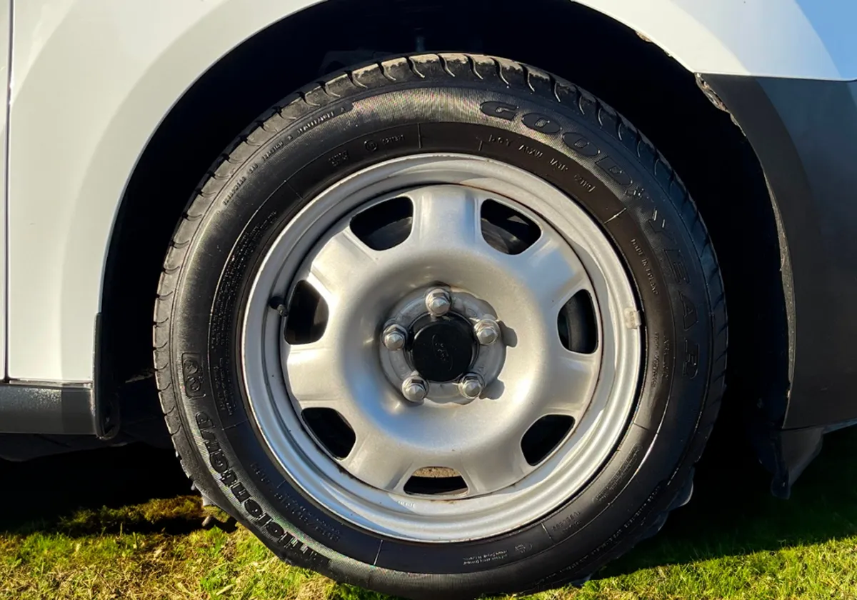 a close up of the wheel of a white Ford Transit Connect.